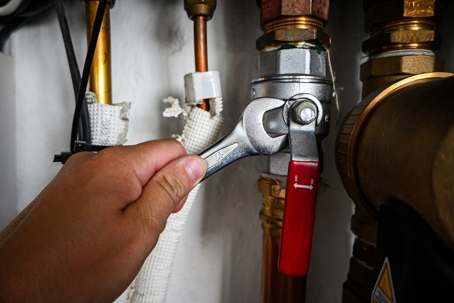 Plumber servicing a lever-style water shutoff valve